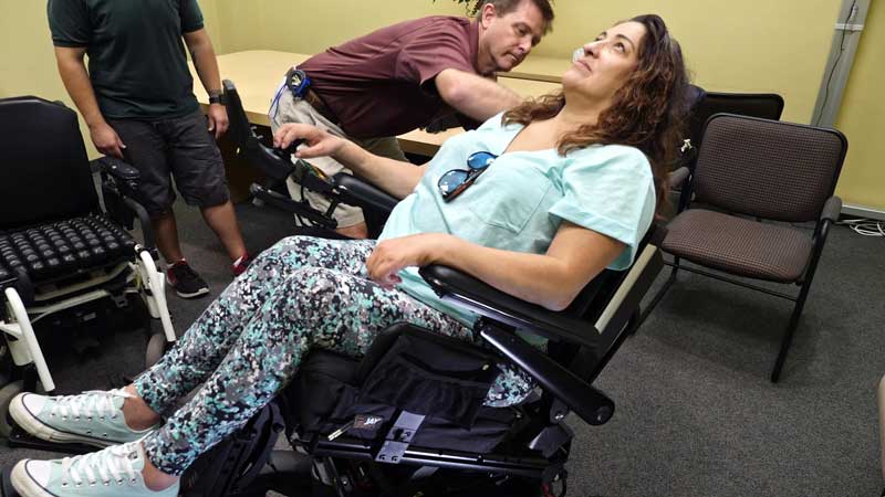 A woman testing new seating adjustments in her power wheelchair